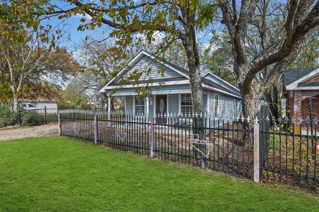 2002 Northeast Main Street Ennis, TX 75119 - Photo 4 of 30 a view of a house with a small yard and a large tree