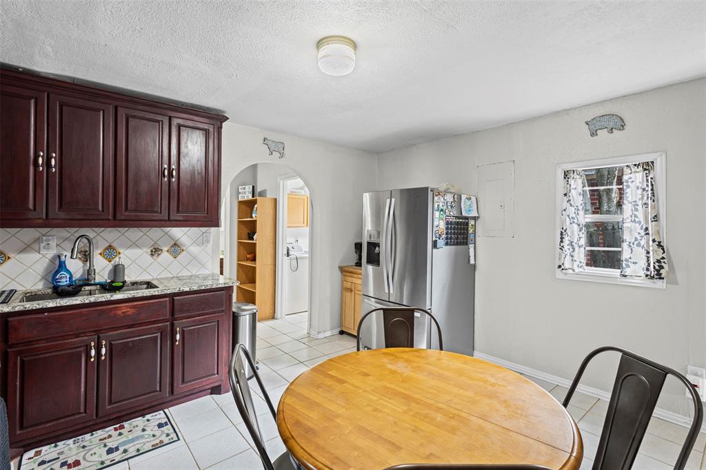 2002 Northeast Main Street Ennis, TX 75119 - Photo 10 of 30 a kitchen with stainless steel appliances granite countertop a refrigerator and wooden cabinets