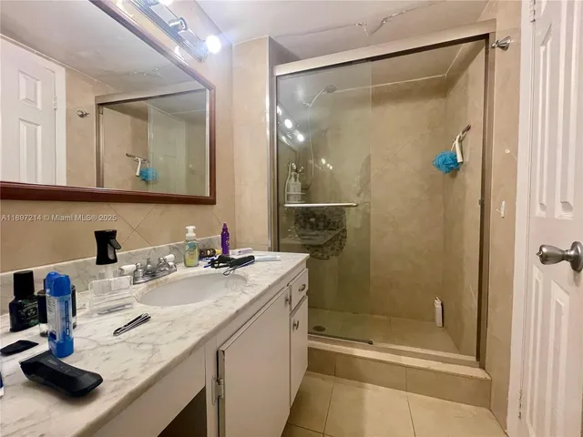 a bathroom with a granite countertop sink mirror and shower