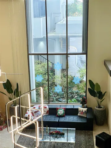 a living room with furniture and a floor to ceiling window
