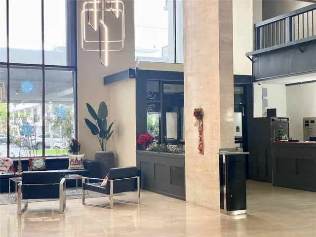a living room with furniture a large window and kitchen view