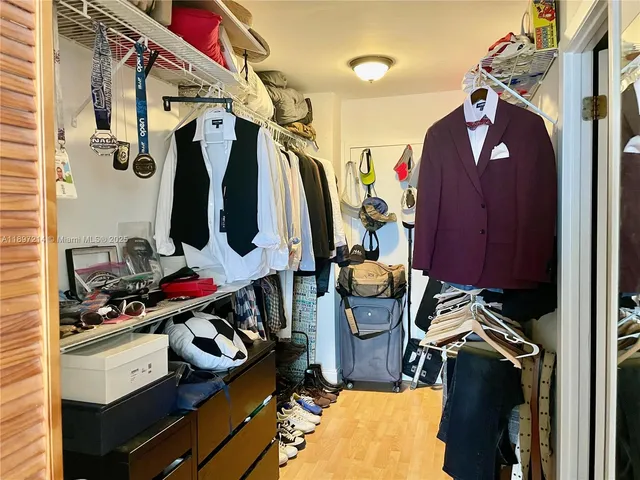 a view of walk in closet with clothes and shoes