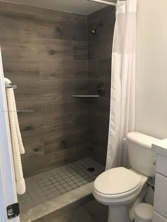a bathroom with a toilet and a shower