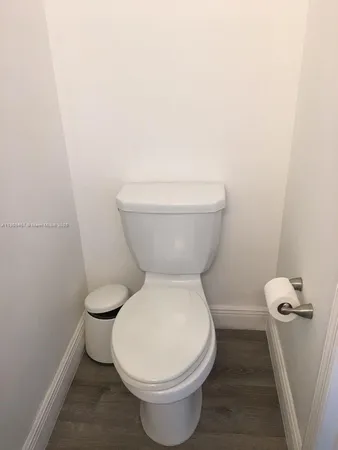 a white toilet sitting next to a white wall