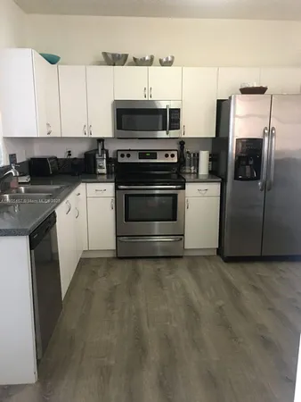 a kitchen with stainless steel appliances a stove a sink and a microwave