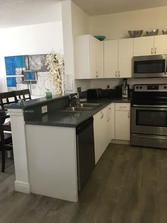 a kitchen with stainless steel appliances a stove a sink and a microwave