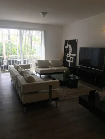 a living room with furniture wooden floor and a window