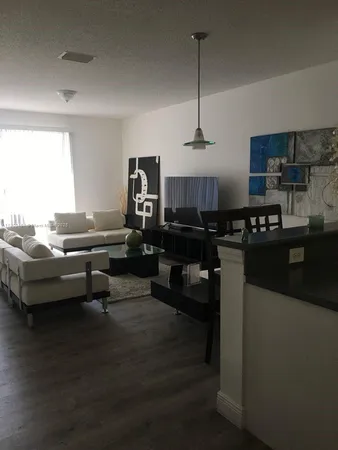 a living room with furniture and kitchen view