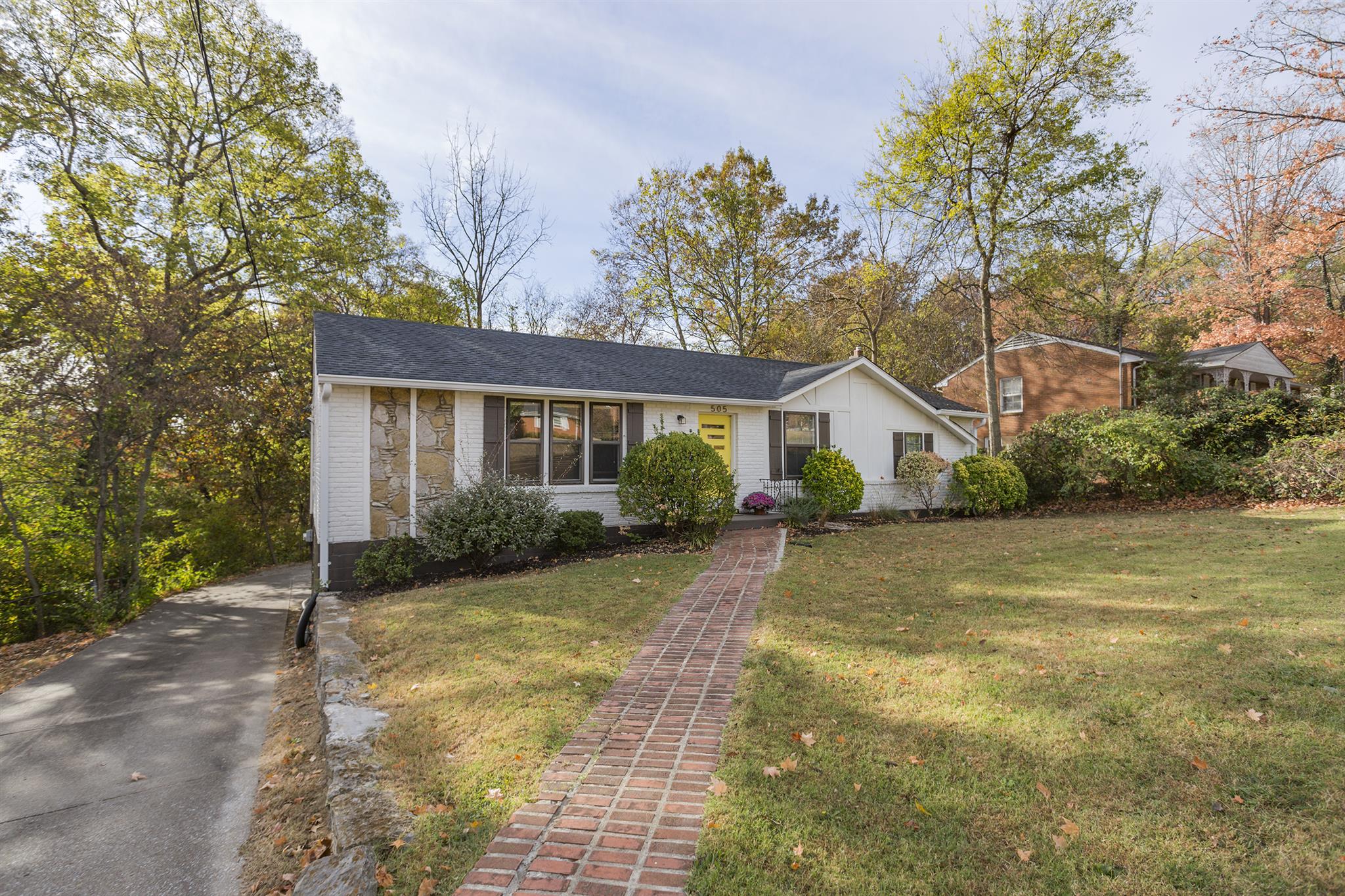a view of a house with backyard and trees