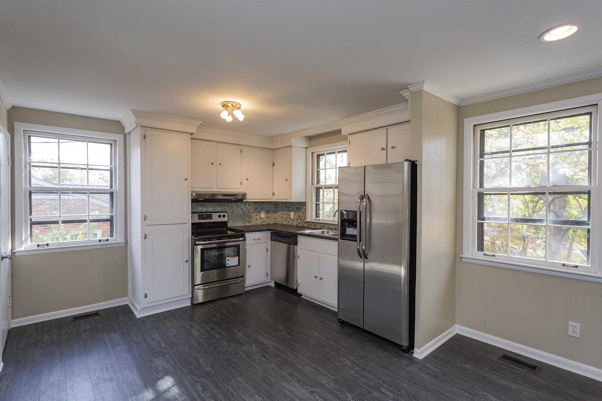 505 Harding Place Nashville, TN 37211 - Photo 6 of 24 a kitchen with stainless steel appliances granite countertop a refrigerator a sink dishwasher a stove and white countertops with wooden floor