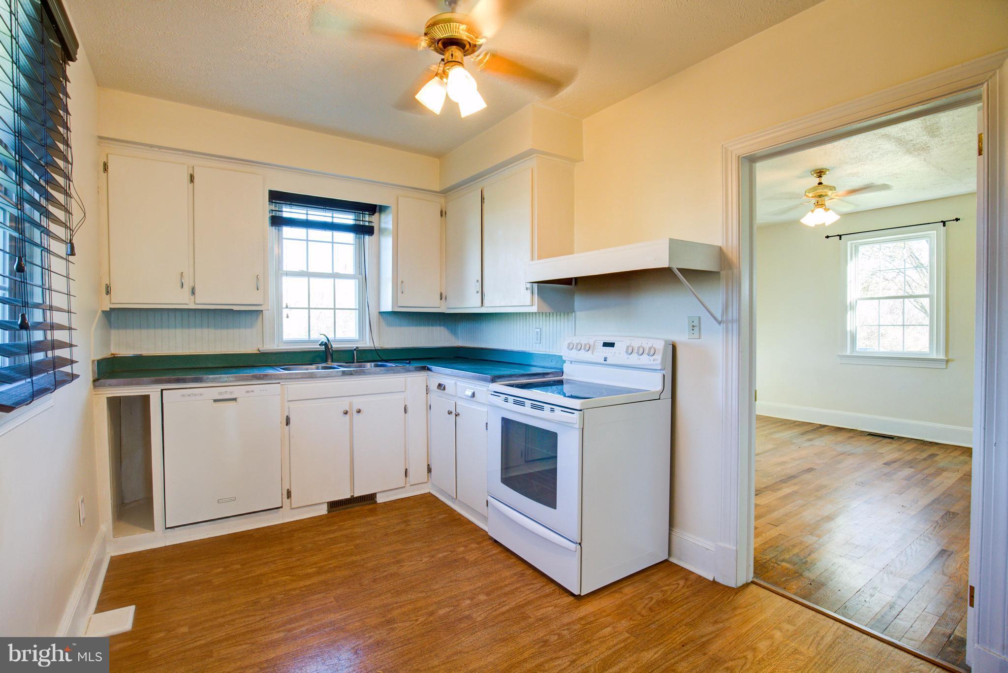 155 Summerville Road Boyce, VA 22620 - Photo 15 of 20 a kitchen with stainless steel appliances granite countertop a stove a sink and white cabinets with wooden floor