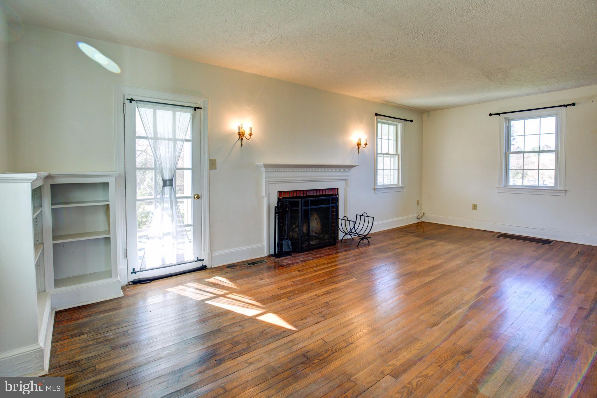 155 Summerville Road Boyce, VA 22620 - Photo 7 of 20 an empty room with wooden floor fireplace and windows