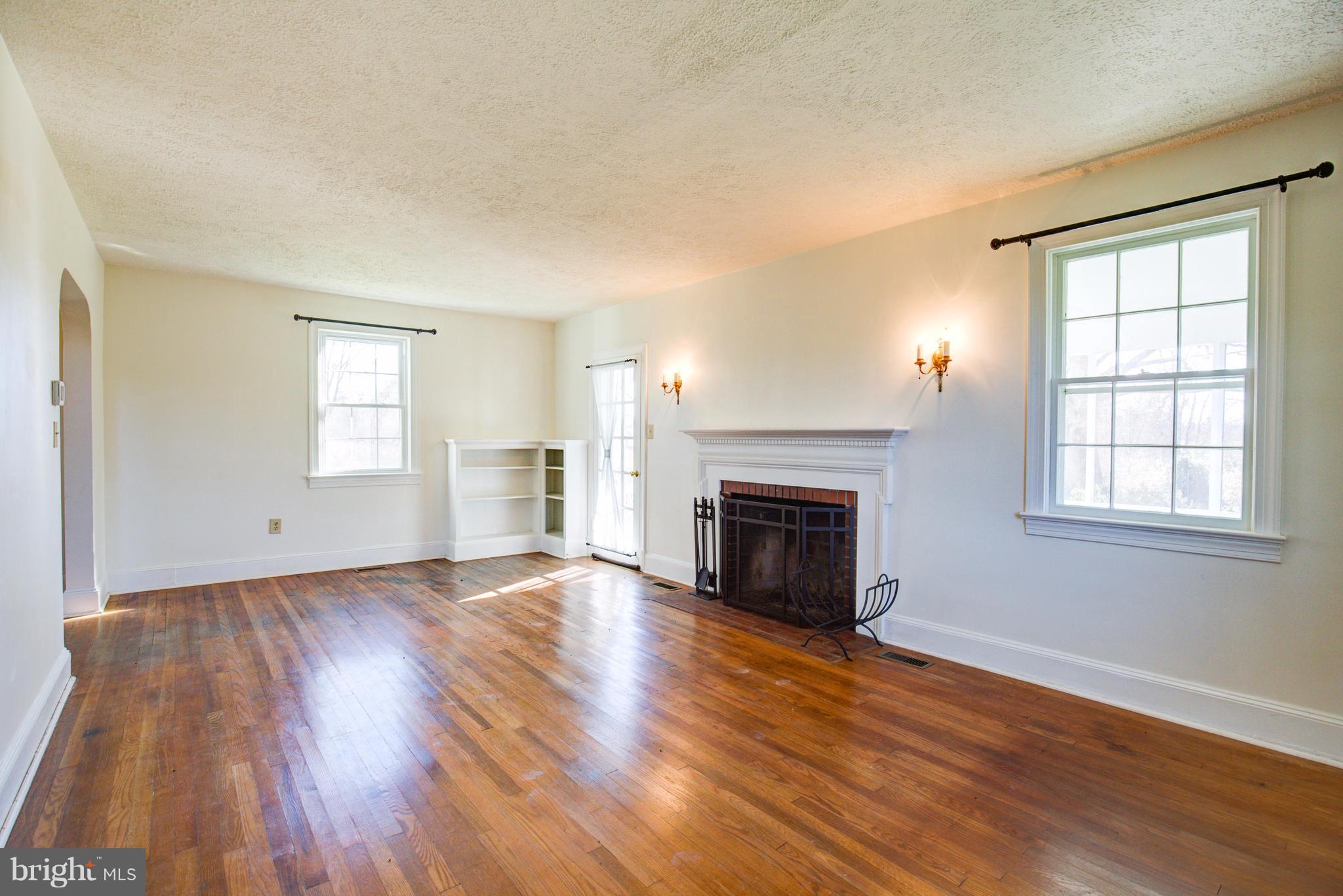 155 Summerville Road Boyce, VA 22620 - Photo 8 of 20 an empty room with wooden floor fireplace and windows
