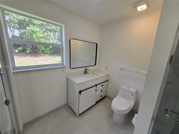 a bathroom with a sink mirror and toilet