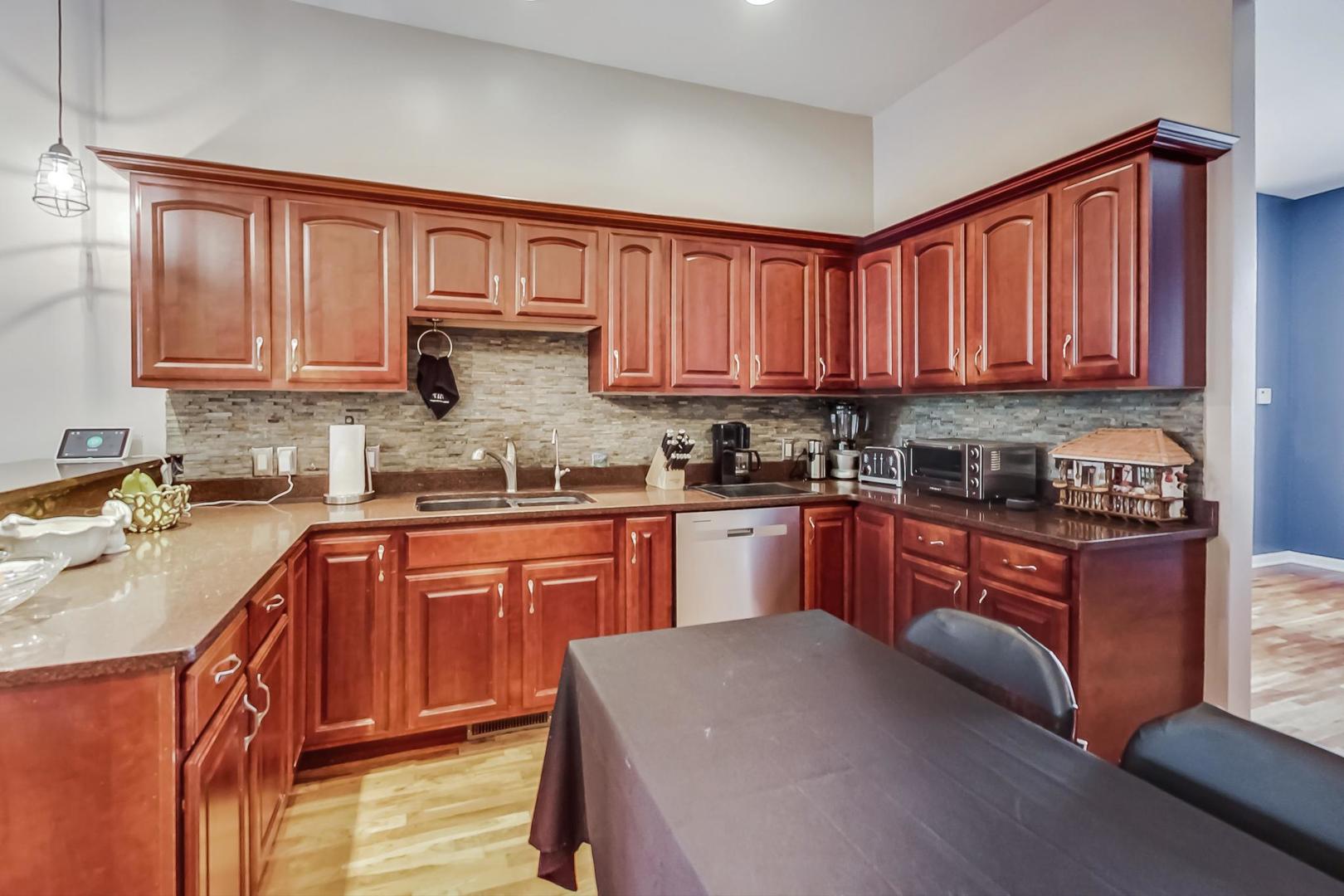 2101 Bull Ridge Drive McHenry, IL 60050 - Photo 17 of 83 a kitchen with stainless steel appliances granite countertop wooden cabinets a sink and dishwasher a stove with wooden floor