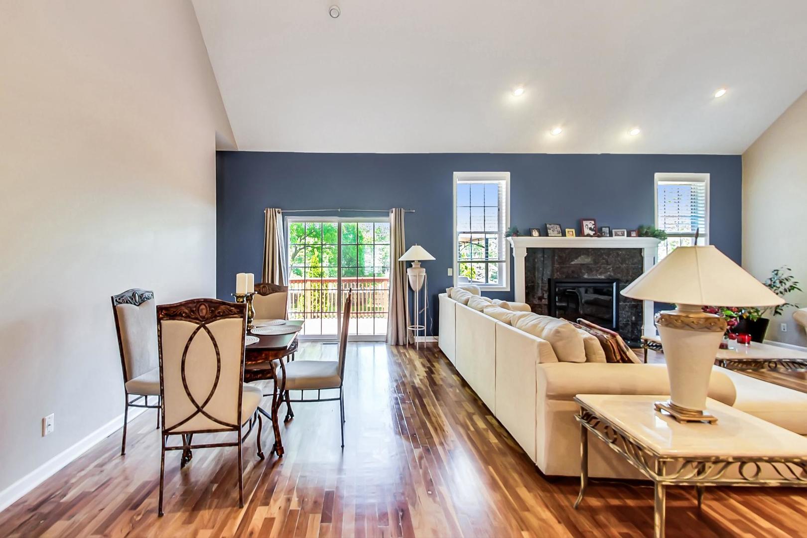 2101 Bull Ridge Drive McHenry, IL 60050 - Photo 18 of 83 a living room with furniture a fireplace and a dining table with wooden floor