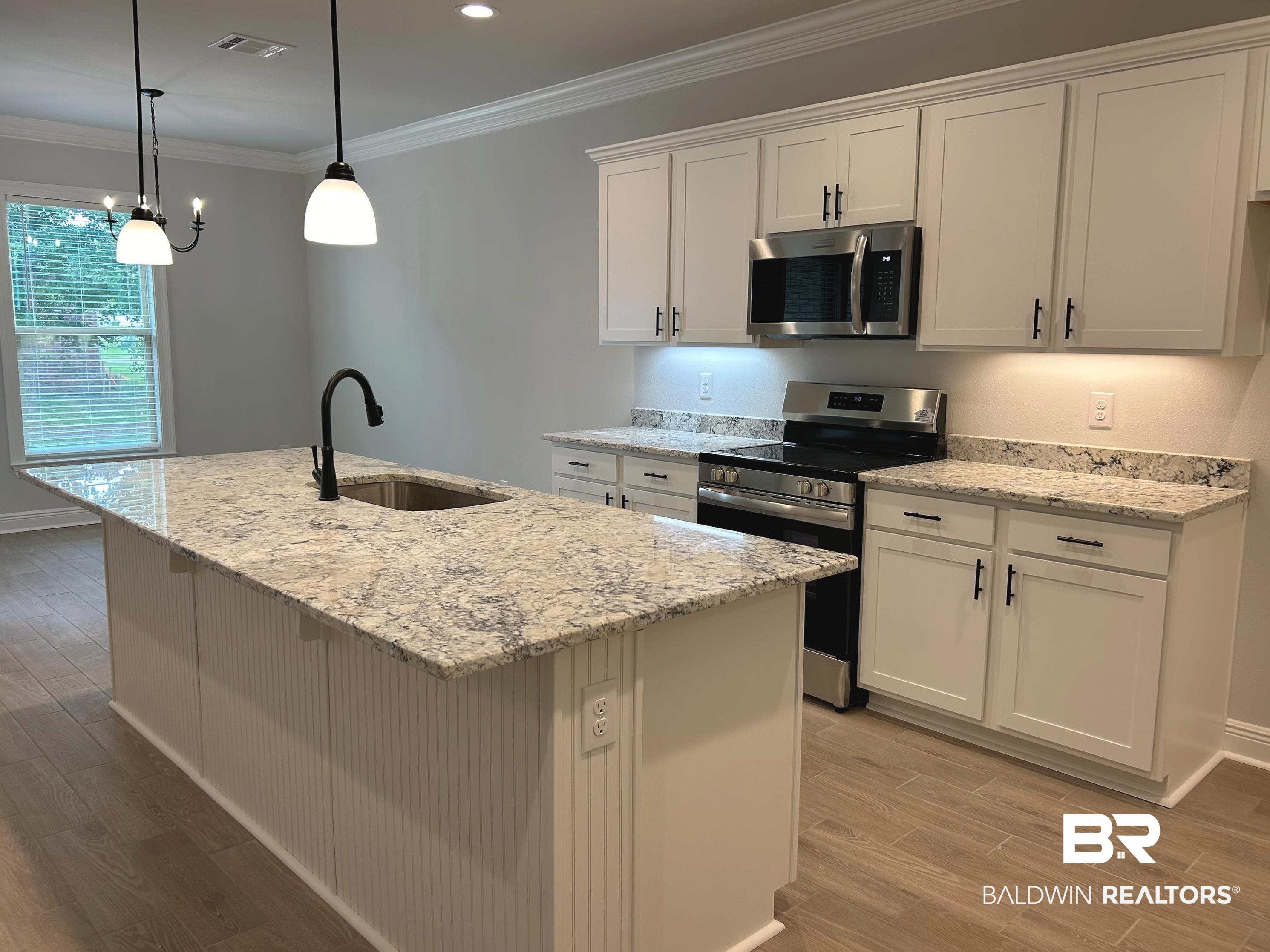 860 Sumter Loop Foley, AL 36535 - Photo 8 of 26 Kitchen featuring appliances with stainless steel finishes, a center island with sink, and white cabinets
