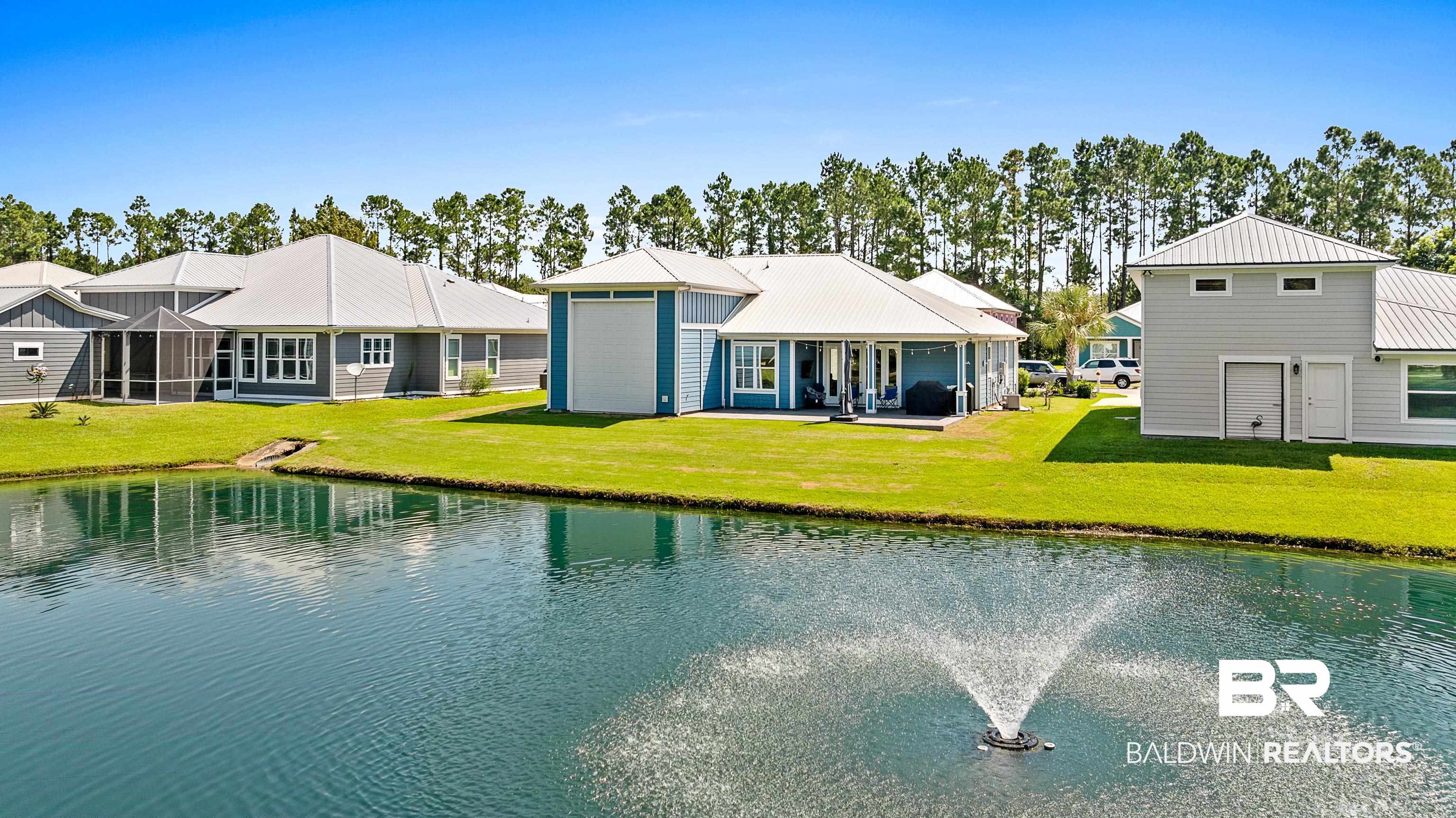 12329 Reunion Place, Unit LOT 38 Foley, AL 36535 - Photo 37 of 43 Rear view of property with a metal roof, a yard, a patio area, a water view, and a sunroom