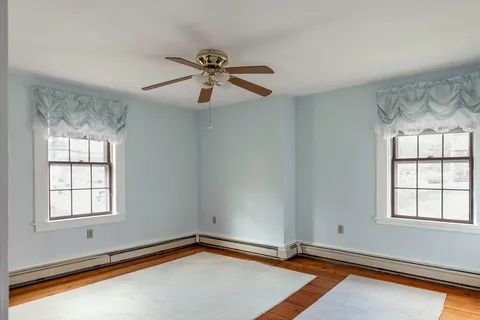 a view of an empty room with window and cabinet