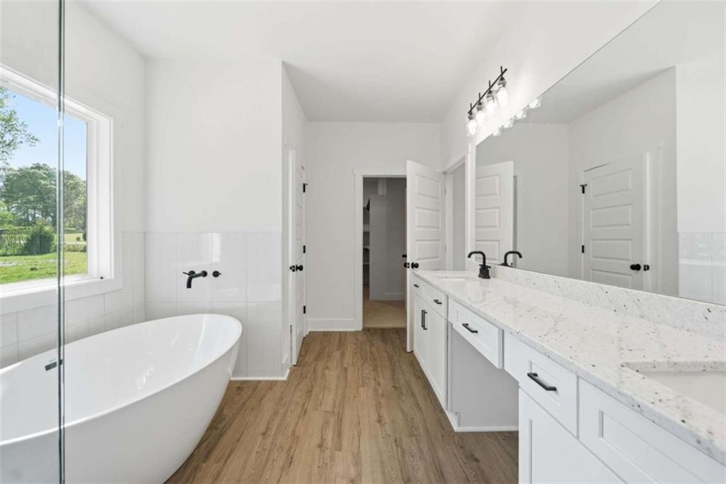 11691 Hazelbrand Road Northeast Covington, GA 30014 - Photo 35 of 53 a spacious bathroom with a granite countertop sink mirror and a bathtub