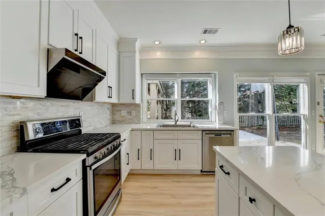 a kitchen with stainless steel appliances granite countertop a sink stove and microwave