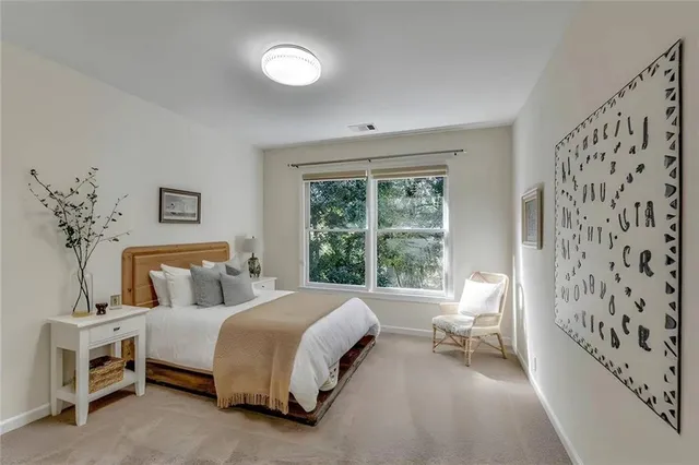 a spacious bedroom with a bed and a chair