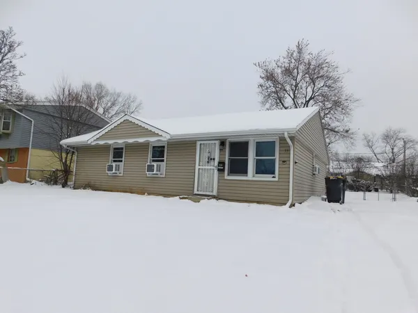 a front view of a house with a yard covered in snow