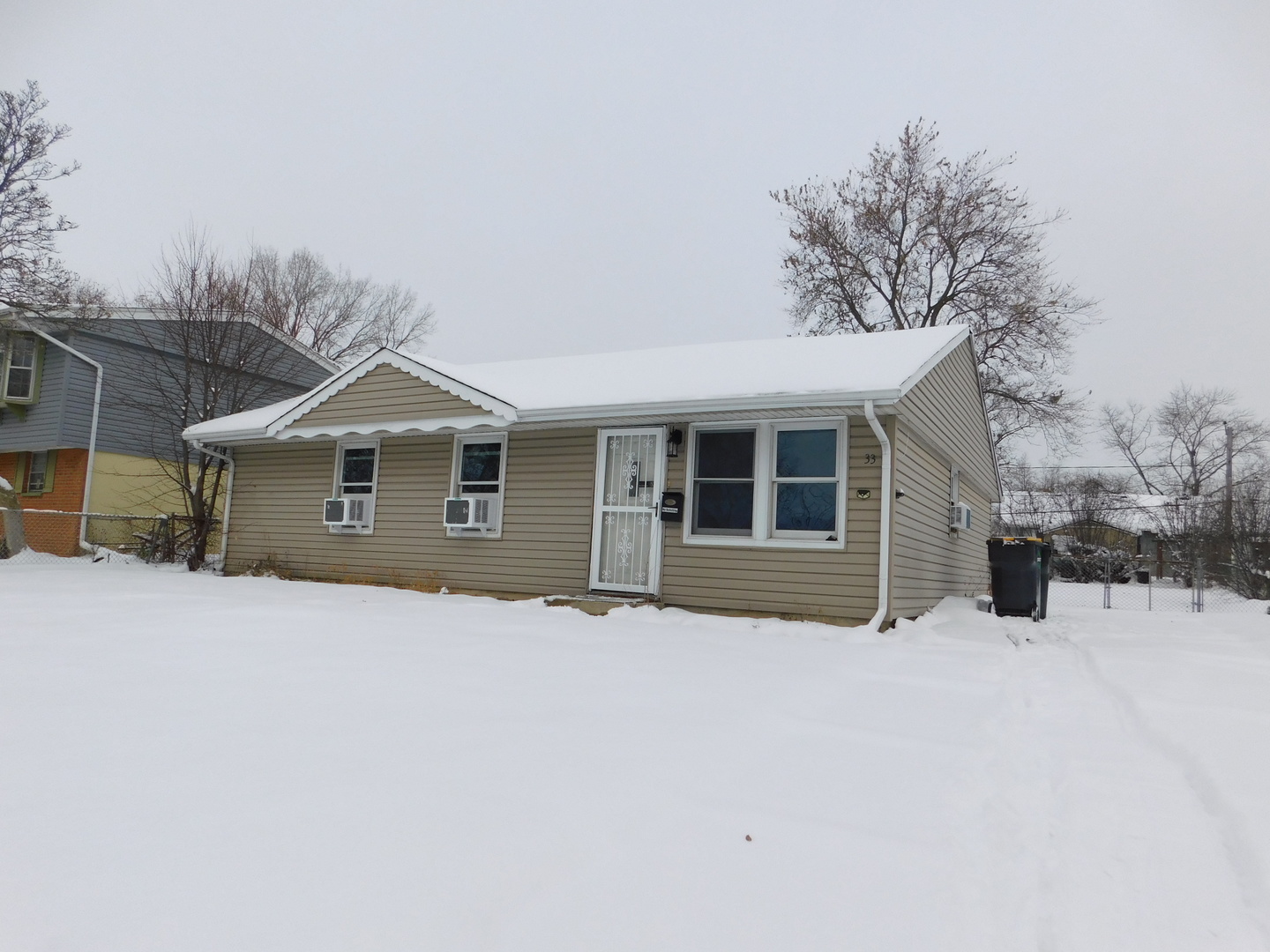 33 Hawthorne Lane Streamwood, IL 60107 - Photo 1 of 15 a front view of a house with a yard covered in snow