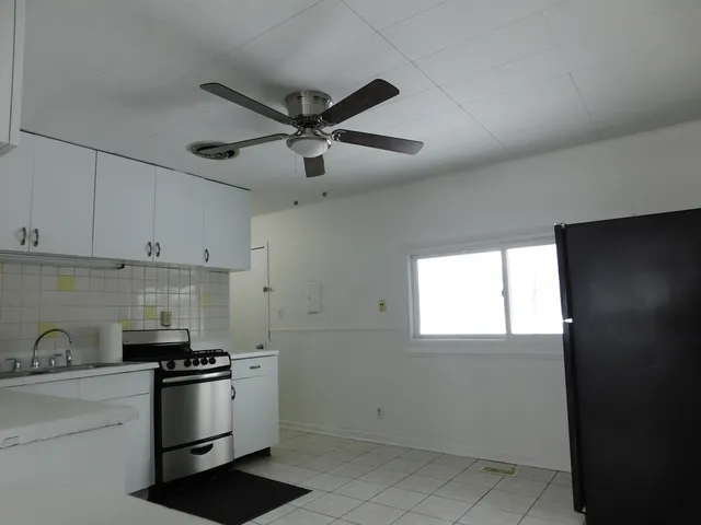 a kitchen with a stove cabinets and a refrigerator