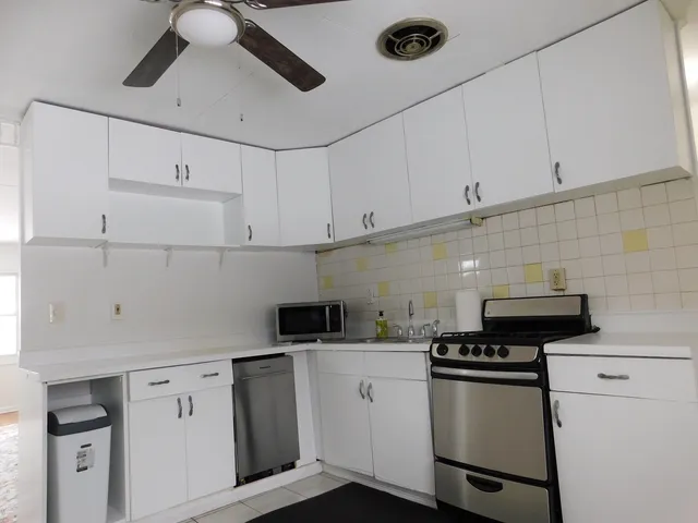 a kitchen with stainless steel appliances a white stove top oven and cabinets