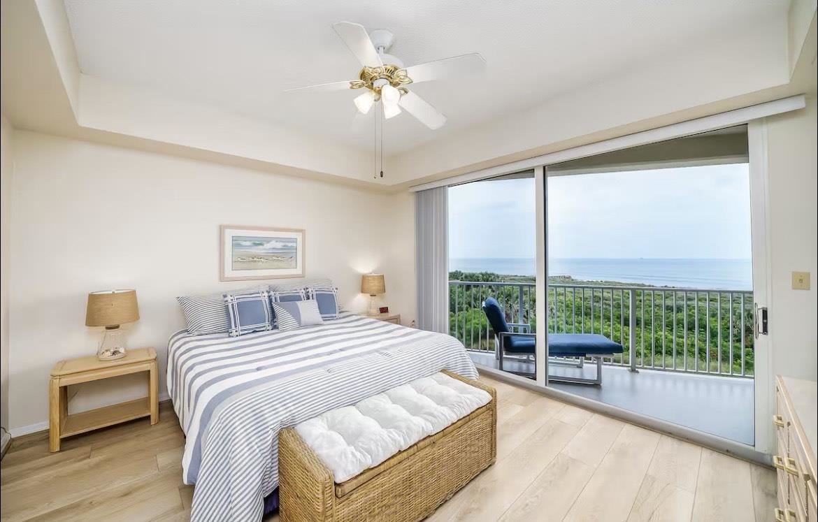 104 Surfview Drive, Unit 1307 Palm Coast, FL 32137 - Photo 2 of 17 a bedroom with a large bed and a chandelier