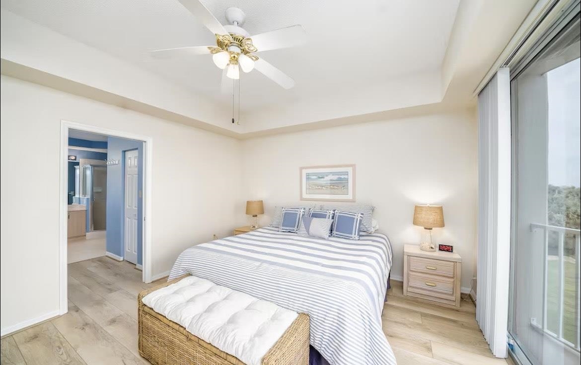 104 Surfview Drive, Unit 1307 Palm Coast, FL 32137 - Photo 6 of 17 a bedroom with a white bed and a chandelier
