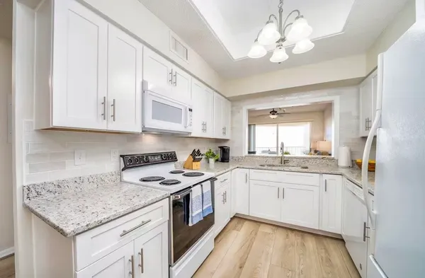 a kitchen with stainless steel appliances granite countertop a sink stove cabinets and refrigerator