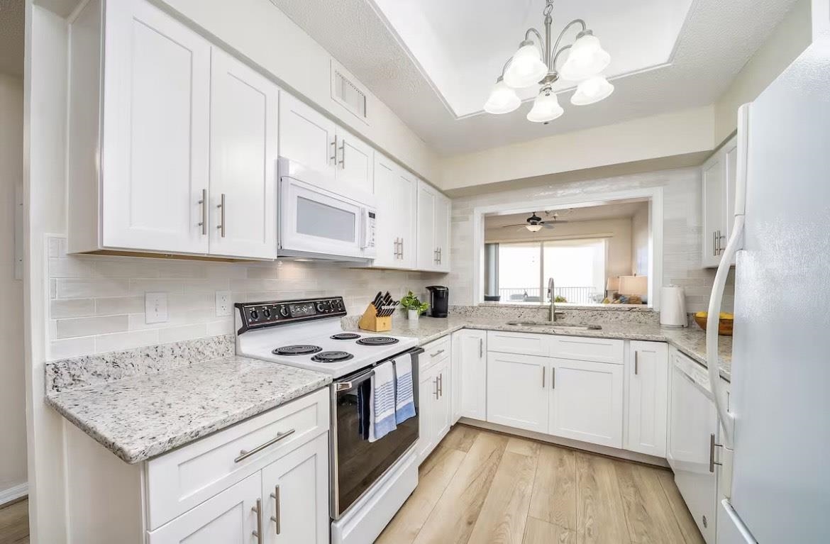 104 Surfview Drive, Unit 1307 Palm Coast, FL 32137 - Photo 10 of 17 a kitchen with stainless steel appliances granite countertop a sink stove cabinets and refrigerator