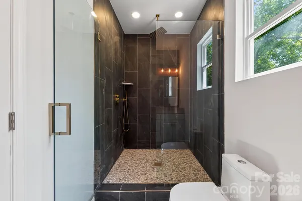 a kitchen with stainless steel appliances granite countertop a stove a sink and white cabinets