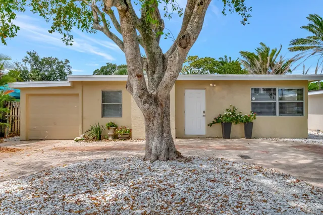 a front view of a house with a yard and potted plants