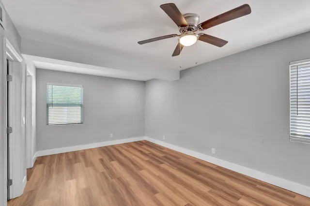 an empty room with a window and a fan