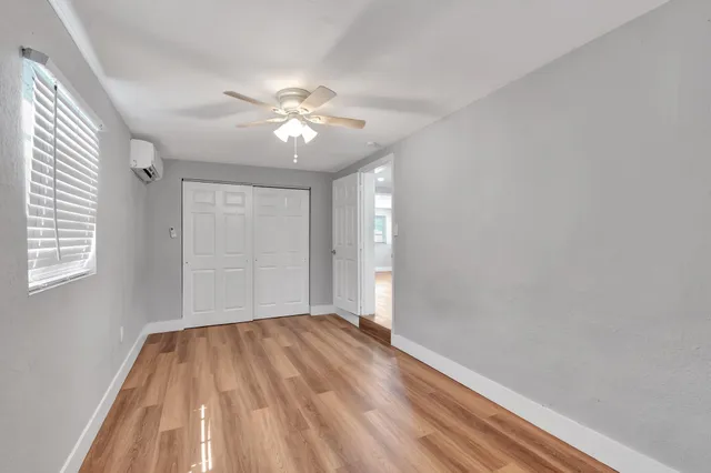 a view of empty room with wooden floor and fan