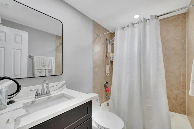 a bathroom with a sink vanity mirror and toilet