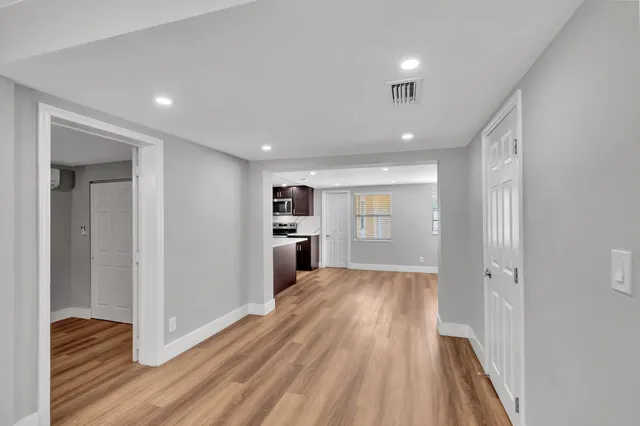 a view of a big room with wooden floor closet and windows