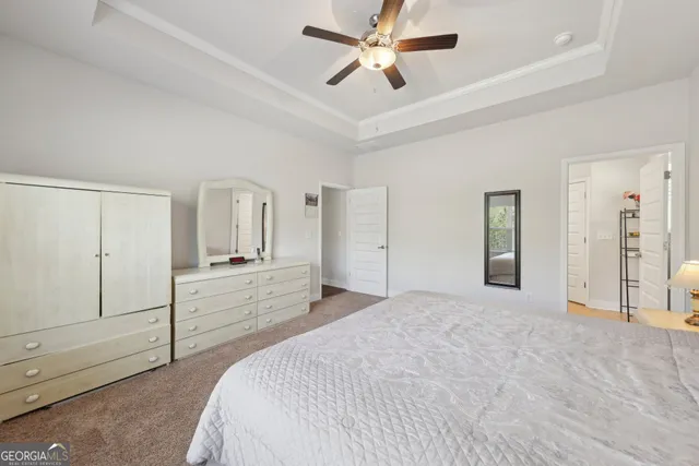 a spacious bedroom with a bed and a chandelier