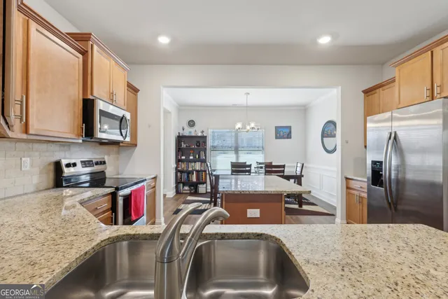a kitchen with stainless steel appliances granite countertop a sink refrigerator and microwave