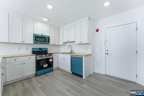 a kitchen with sink a microwave and cabinets