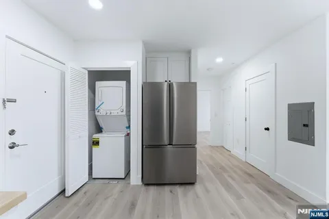 a kitchen with a refrigerator and wooden floor