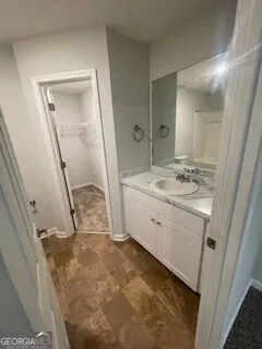 a bathroom with a sink a granite countertop toilet a mirror and vanity