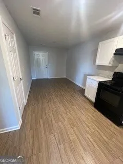 a large kitchen with stainless steel appliances wooden floors and wooden cabinets