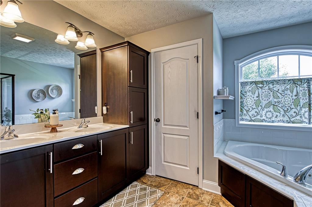 108 Seaton Crest Drive Mars, PA 16046 - Photo 14 of 25 a en suite bathroom with a double vanity sink a large mirror and a bathtub