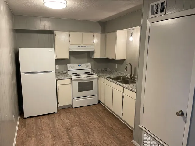 a kitchen with white cabinets and white appliances
