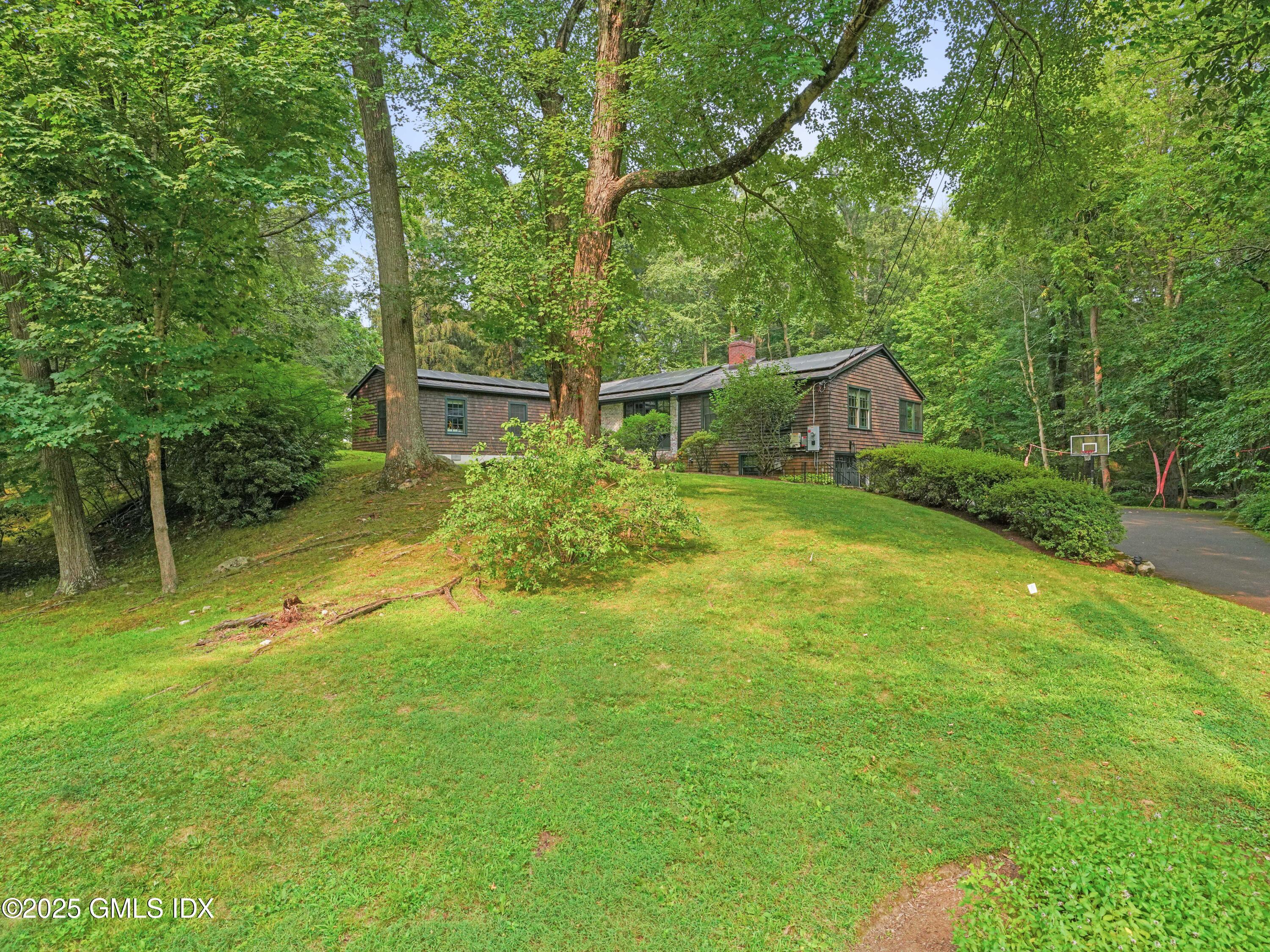 25 Jeffrey Road Greenwich, CT 06830 - Photo 33 of 35 a backyard of a house with plants and large trees