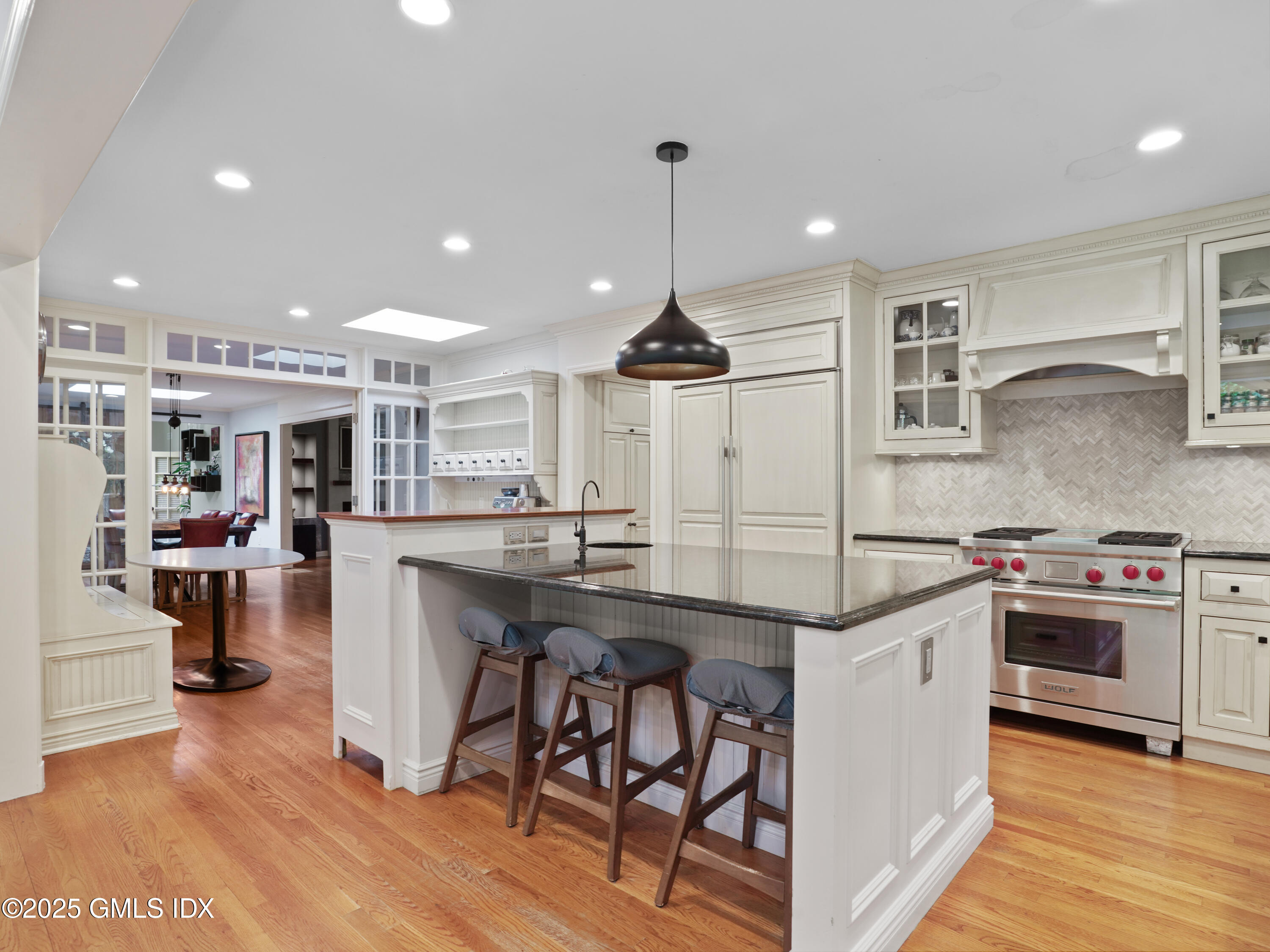 25 Jeffrey Road Greenwich, CT 06830 - Photo 8 of 35 a kitchen with stainless steel appliances granite countertop a sink a stove a refrigerator and island with wooden floor